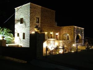 een gebouw met 's nachts verlichting bij Xenonas Thalis in Skoutarion