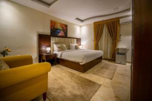 um quarto de hotel com uma cama e um sofá em ركن مدهال للوحدات السكنية المفروشة em Jazan