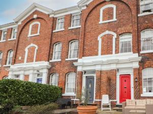 une porte rouge sur le côté d'un bâtiment en briques dans l'établissement 12 Deva Terrace, à Chester