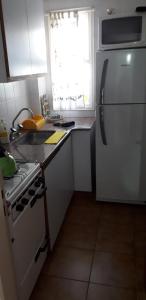 Il comprend une cuisine équipée d'un réfrigérateur blanc et d'une cuisinière. dans l'établissement Horizontal, à Mar del Plata