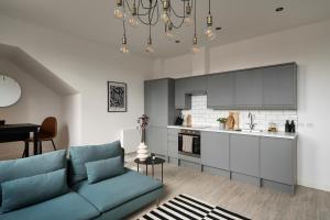 a living room with a blue couch and a kitchen at OneFiveSix - Unique Apartments in Birmingham