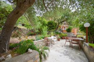 a garden with a table and chairs and a tree at Apartment Ivanka in Banjol +8 photos