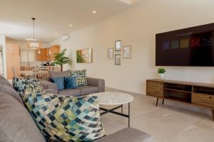 a living room with a couch and a flat screen tv at Brand new home with heated pool in Puerto Peñasco