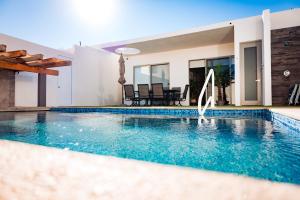 a swimming pool in front of a villa at Brand new home with heated pool in Puerto Peñasco