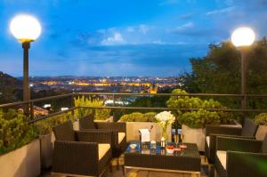 a patio with a view of a city at night at NH Prague City in Prague