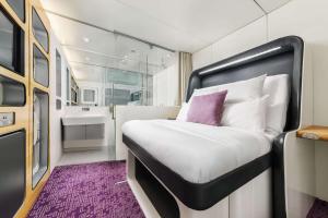 a small bedroom with a bed and a bathroom at YOTELAIR London Gatwick Airport in Horley