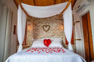 a bed with a red heart on top of it at Chalé Formoso - Chalé Romântico com Hidromassagem in Serra de São Bento