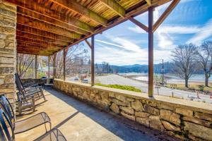 a large stone wall on a porch with a view of a river at Morris Villa in Lake Junaluska