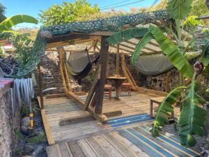 a wooden deck with a hammock in a garden at Les hamacs aux Saintes in Terre-de-Haut