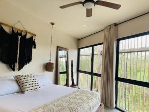- une chambre avec un lit, un ventilateur de plafond et des fenêtres dans l'établissement Vida Boho Apart 12 with special fee to access Hotel Bardo, à Tulum 26 autres photos