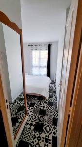 um quarto com uma cama branca e um espelho em Appartement proche Disneyland, Val d'Europe, Paris #2 em Serris