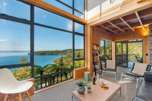 a living room with large windows and a view of the ocean at Wai Marino - Taupo in Taupo