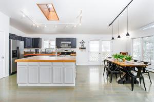 a kitchen with white cabinets and a wooden table at Falke Inn in Anchorage