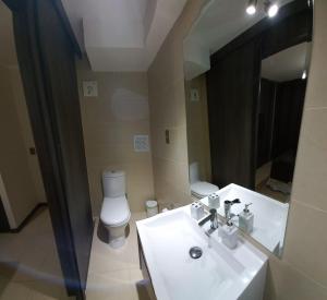 a bathroom with a sink and a toilet and a mirror at DEPARTAMENTO EDIFICIO AZUL I in Iquique