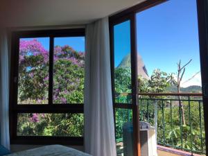 a room with a window with a view of trees at Flat Vista Azul Hotel in Pedra Azul
