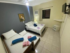 a small room with two beds and a couch at Pousada Golden House - Próxima ao Thermas no Centro de Aguas in Águas de São Pedro