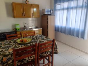 a kitchen with a table with a plate of fruit on it at Pousada Maraka in Florianópolis