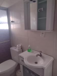 bagno con lavandino, servizi igienici e specchio di Pousada Maraka a Florianópolis