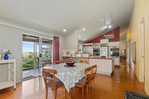 a kitchen and dining room with a table and chairs at Francis Orchard Country Stay - Waipu Holiday Home in Waipu Cove
