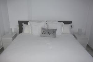 a bed with a pillow with the word love on it at Los Colimbos in Torremolinos