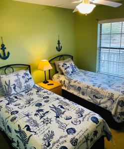 um quarto com 2 camas com lençóis azuis e brancos em True Blue Hideaway em Pawleys Island