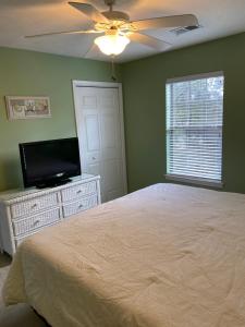 um quarto com uma cama e uma televisão de ecrã plano em True Blue Hideaway em Pawleys Island