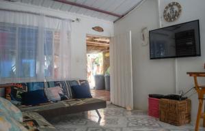 een woonkamer met een bank en een flatscreen-tv bij L' Europe in Puerto Limón