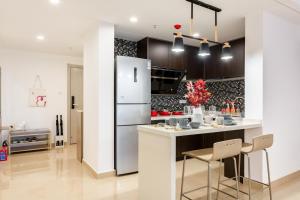 a kitchen with a refrigerator and a counter with chairs at Dali Double bedroom in Dali