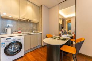 a kitchen with a washing machine and a table at Locals Apartment Place 25 in Hankou