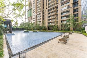 a swimming pool in front of a tall building at Locals Apartment Place 25 in Hankou