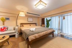 sypialnia z łóżkiem i kanapą w obiekcie Locals Apartment Inn 38 w mieście Jiang'an