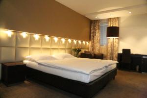a bedroom with a large bed with lights on it at Prielmayerhof HOTEL in Linz