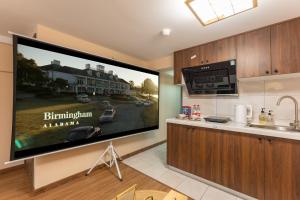 a large flat screen tv on a wall in a kitchen at Locals Apartment Inn 38 in Jiang'an