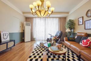 a living room with a couch and a chandelier at Locals Apartment House 02 in Changsha