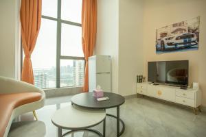 a living room with a table and a tv at Locals Apartment Place 44 in Zhanjiang