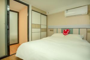 a bedroom with a white bed with a red pillow on it at Locals Apartment Place 44 in Zhanjiang