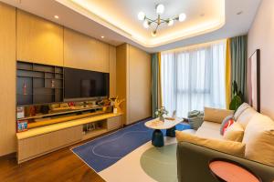 Locals Apartment House 35 في Hankou: غرفة معيشة مع أريكة وتلفزيون