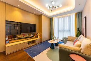 a living room with a couch and a tv at Locals Apartment House 35 in Hankou