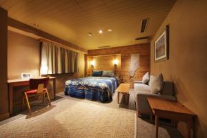 une chambre d'hôtel avec un lit et un canapé dans l'établissement UNWIND Hotel & Bar Sapporo, à Sapporo