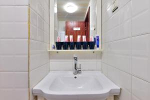 a bathroom with a sink and a shelf with cups at Locals Apartment House 90 in Tianjin +15 photos