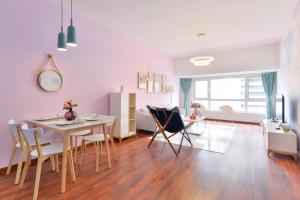 a dining room and living room with a table and chairs at Locals Apartment House 90 in Tianjin