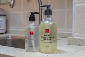 Dos botellas de productos de limpieza sobre un mostrador. en Locals Apartment Inn 01, en Ganzhou