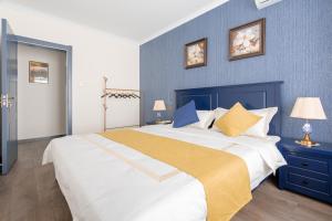 1 dormitorio con 1 cama grande y pared azul en Locals Apartment Inn 01, en Xi'an
