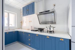 a kitchen with blue cabinets and a stove top oven at Locals Apartment Inn 01 in Xi'an