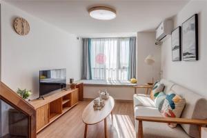 a living room with a couch and a tv at Locals Apartment House 01 in Zhengzhou