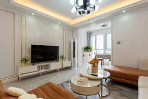 ein Wohnzimmer mit einem Sofa und einem TV in der Unterkunft Locals Apartment Inn 12 in Chang'an