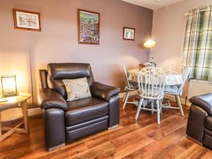 a living room with a chair and a table at Baywood Cottage in Keighley