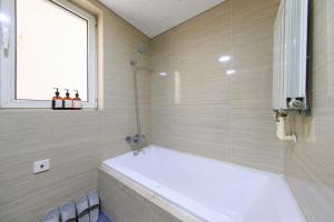 a bathroom with a bath tub and a shower at Locals Apartment Inn 14 in Tianjin +7 photos