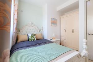 a bedroom with a bed with a white headboard at Locals Apartment Inn 14 in Tianjin