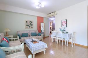 a living room with a couch and chairs and a table at Locals Apartment Inn 14 in Tianjin